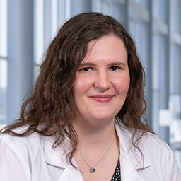 Dr. Abbye Federick wearing a white lab coat, standing in the CUH lobby