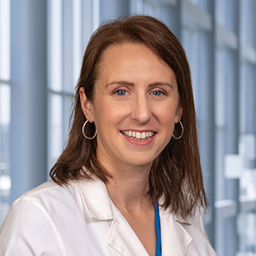 Dr. Kylie Cullinan wearing a white lab coat standing in the Clements University Hospital lobby