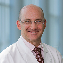 Dr. Craig Glazzer, a man wearing glasses wearing a white lab coat