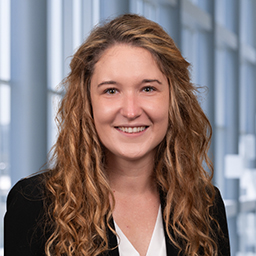 Dr. Jessika Iwanski wearing a white shirt and black jacket standing in the Clements University Hospital lobby