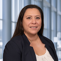 Dr. Laura Isabel Marquez Loza wearing a white shirt and a black jacket standing in the Clements University Hospital lobby