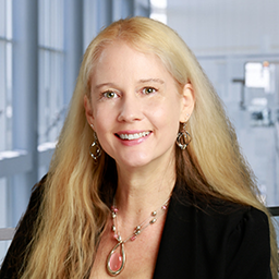 Dr. Shannon Scielzo wearing a black jacket and a white shirt standing in the Clements University Hospital lobby