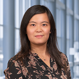 Dr. Hanwen Zhang wearing a dark floral print shirt standing in the Clements University Hospital lobby