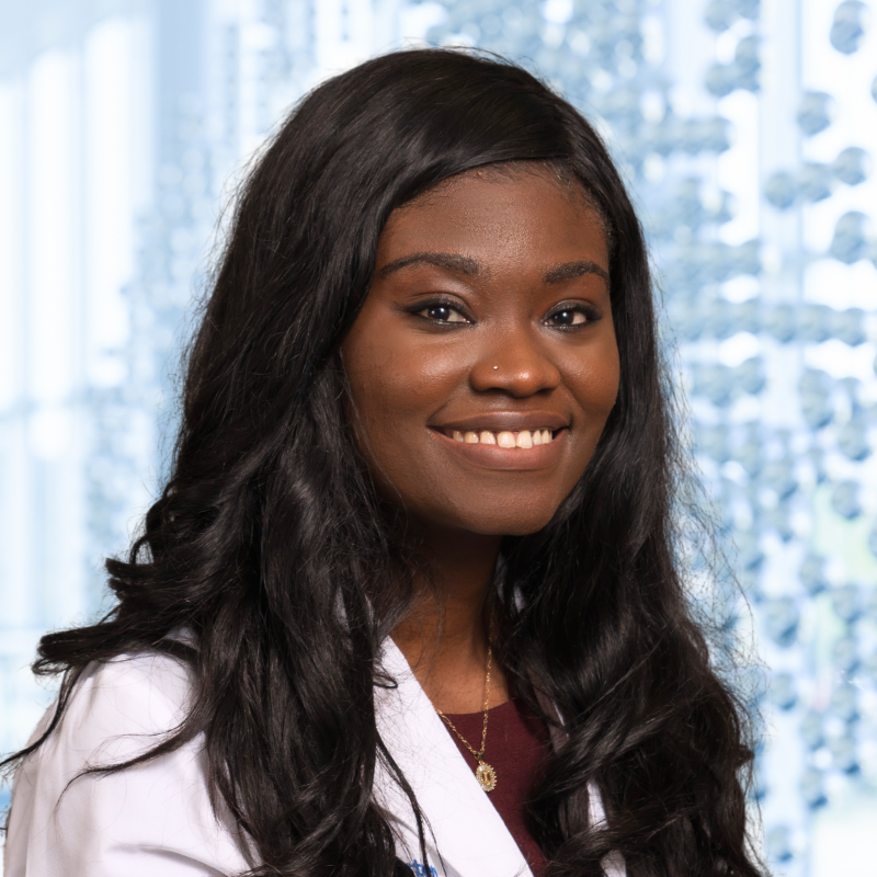 Dr. Ijeoma Eleazu wearing a white lab coat, standing in the Clements University Hospital lobby
