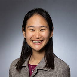 Angela Wang wearing a maroon shirt and grey jacket
