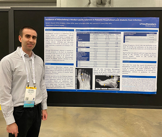 Smiling man standing next to a poster about Diabetic Foot infection.
