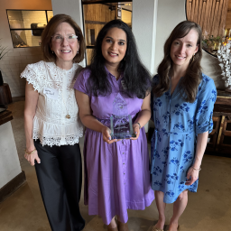 three people holding an awardi