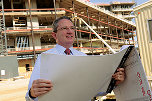 Paul Warner at Construction Site Paul Warner holding blueprints in front of construction