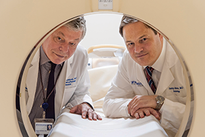 Robert Lenkinski and Suhny Abbara Robert Lenkinski and Suhny Abbara looking through the core of an MRI machine
