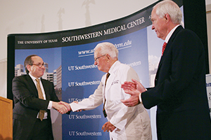 William P. Clements Jr. Gives Unprecedented Gift Mr. Clements, wearing an honorary doctor's coat, shakes hands with Daniel Podololsky