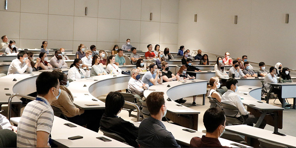 Integrating research and patient care panel discussion. Audience seated in lecture hall listening to panel discussion