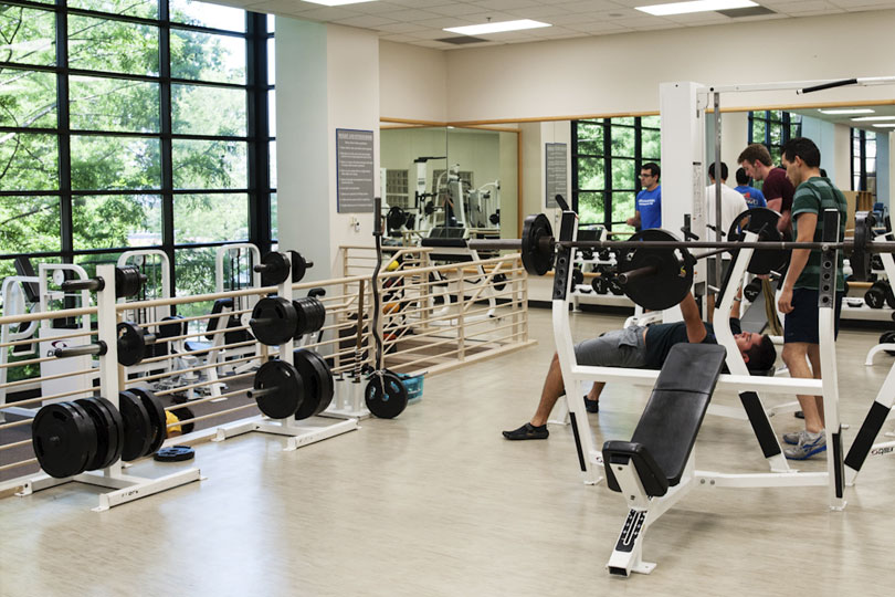 Students work out in the weight room. Weight room in the Student Center