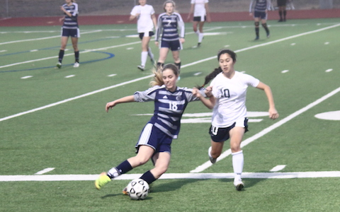 Paige dribbles the ball around a defender. Paige dribbles the ball around a defender