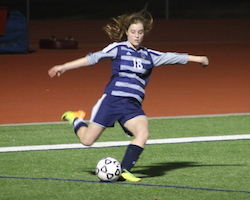 Paige passes the ball during a soccer match. Paige passes the ball