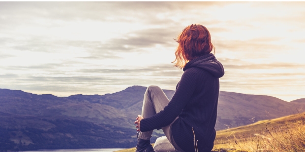woman gazing over misty valley