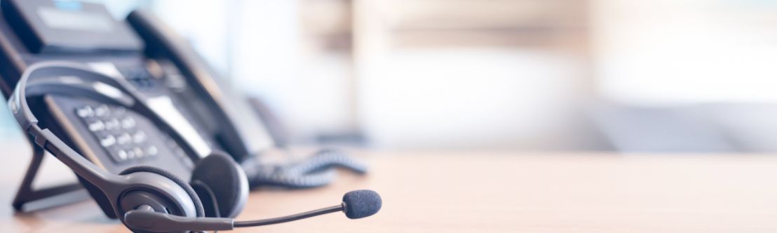 Phone in background attached to a phone headset in foreground