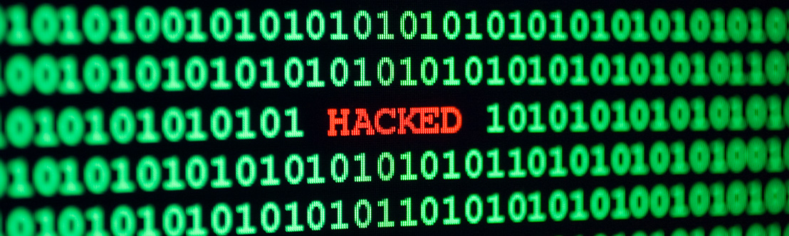A stylistic computer monitor with the word Hacked highlighted in red with 1 and 0 in green as the background with a narrow focus
