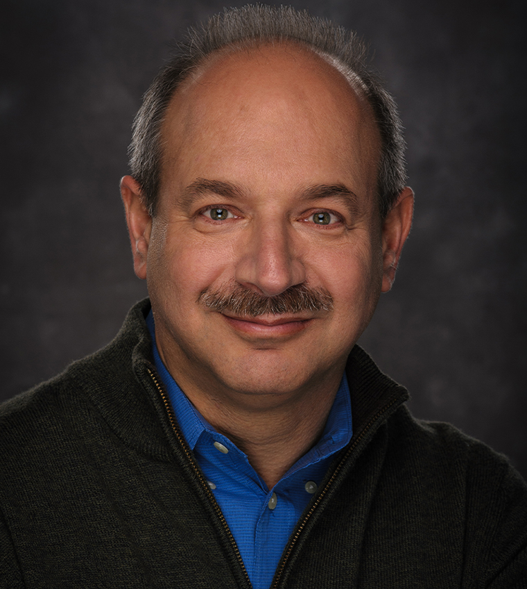 Bruce Beutler, M.D. A man with glasses and a purple shirt