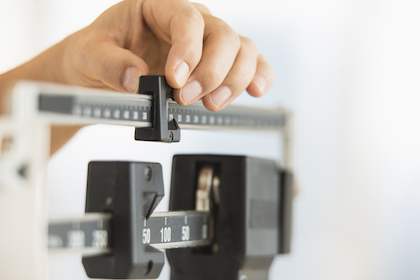 A person adjusting a scale with their hand