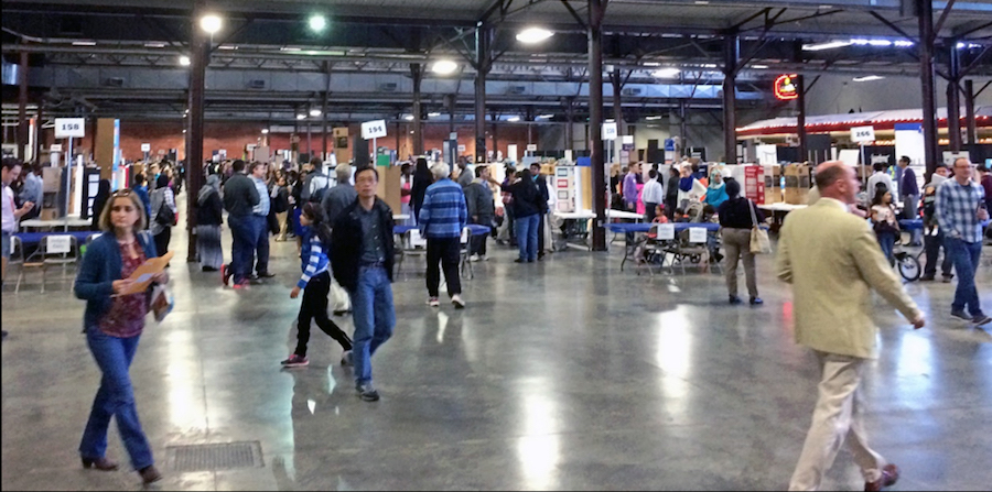 Mandatory participation in high school science fairs is counterproductive and noncompetitive tracts should be offered that focus on scientific practices and learning vs. competition, researchers suggest. Men and women walk around in a large exhibition area