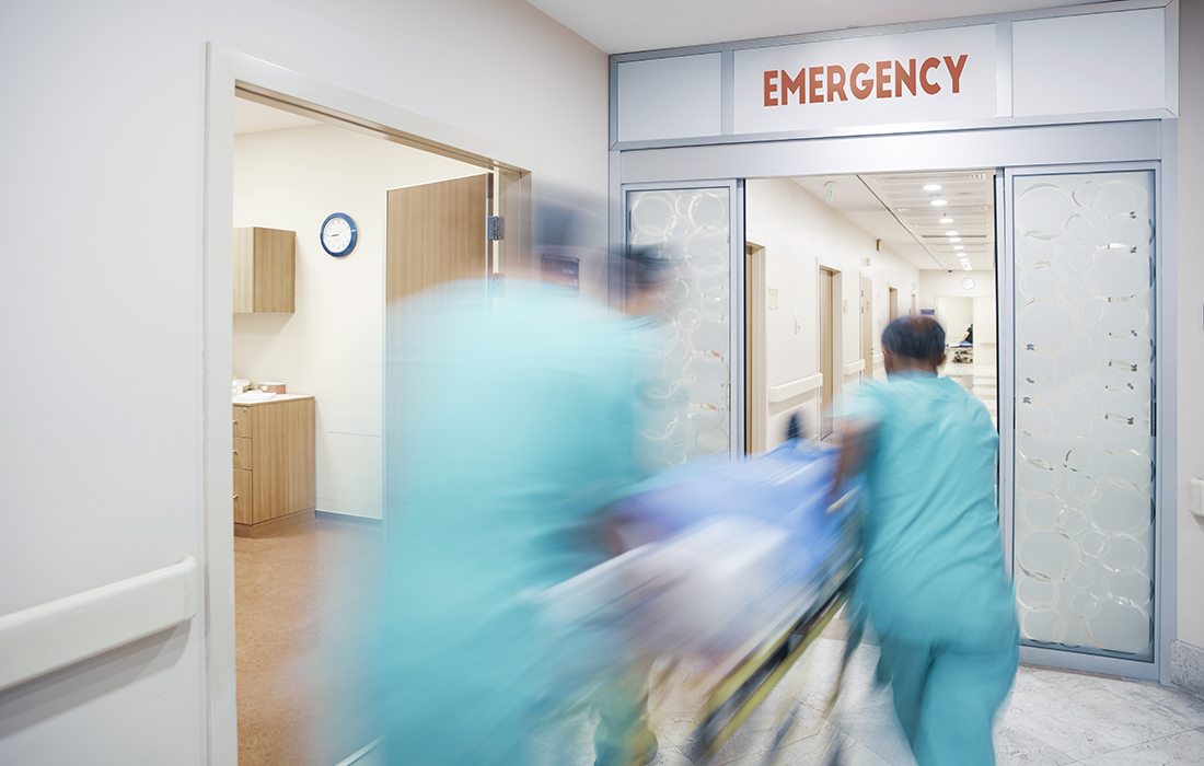 Medical workers rush a patient on a gurney to the ER