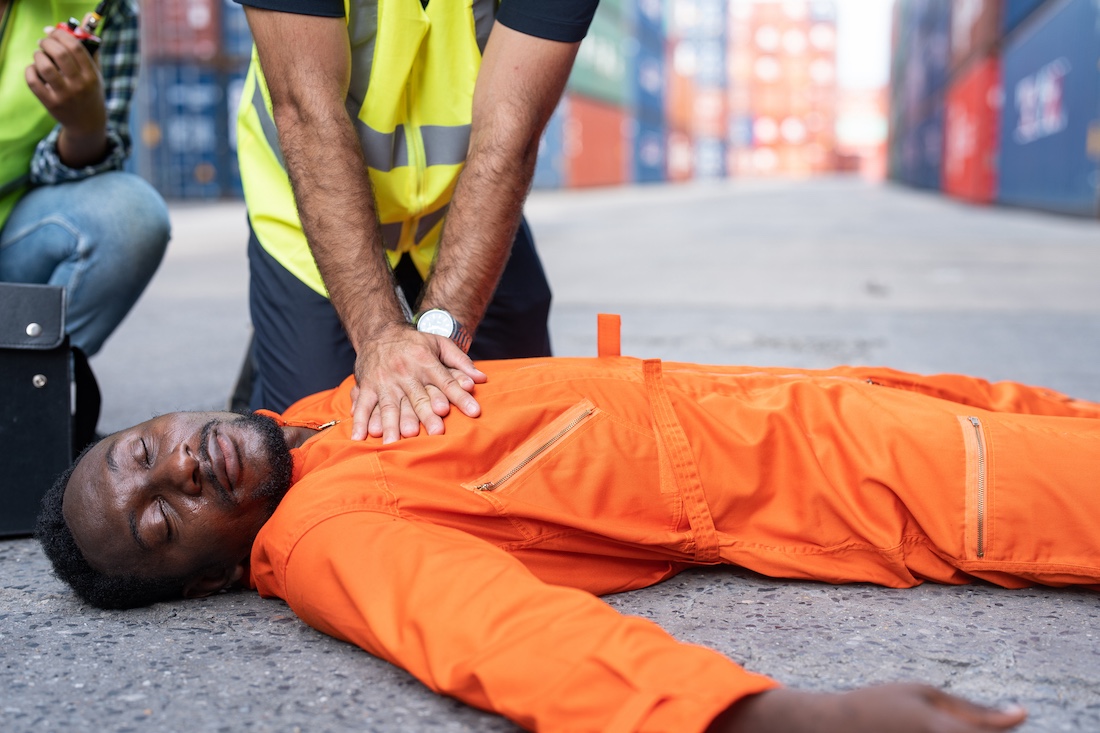 First aid help CPR construction worker who has an accident cardiac arrest at a construction site.