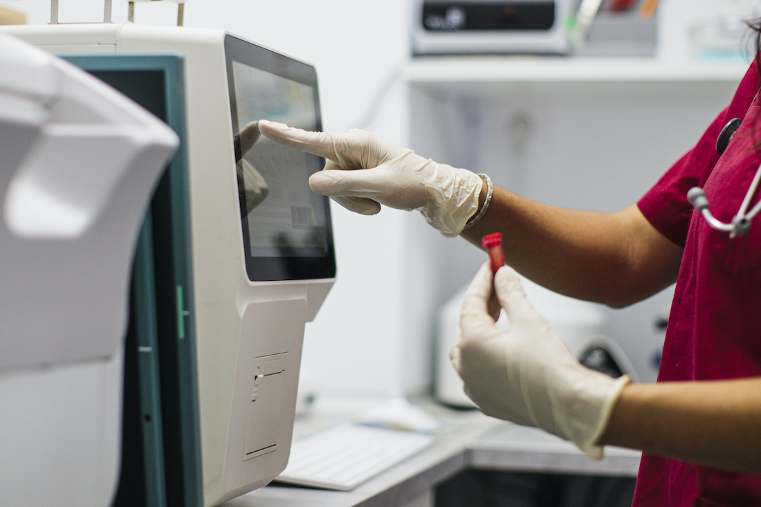 Technician woman with test tube in laboratory, blood analysis 