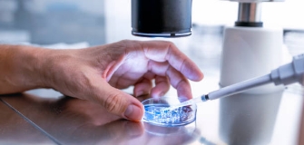 A man's hand touching scientific equipment