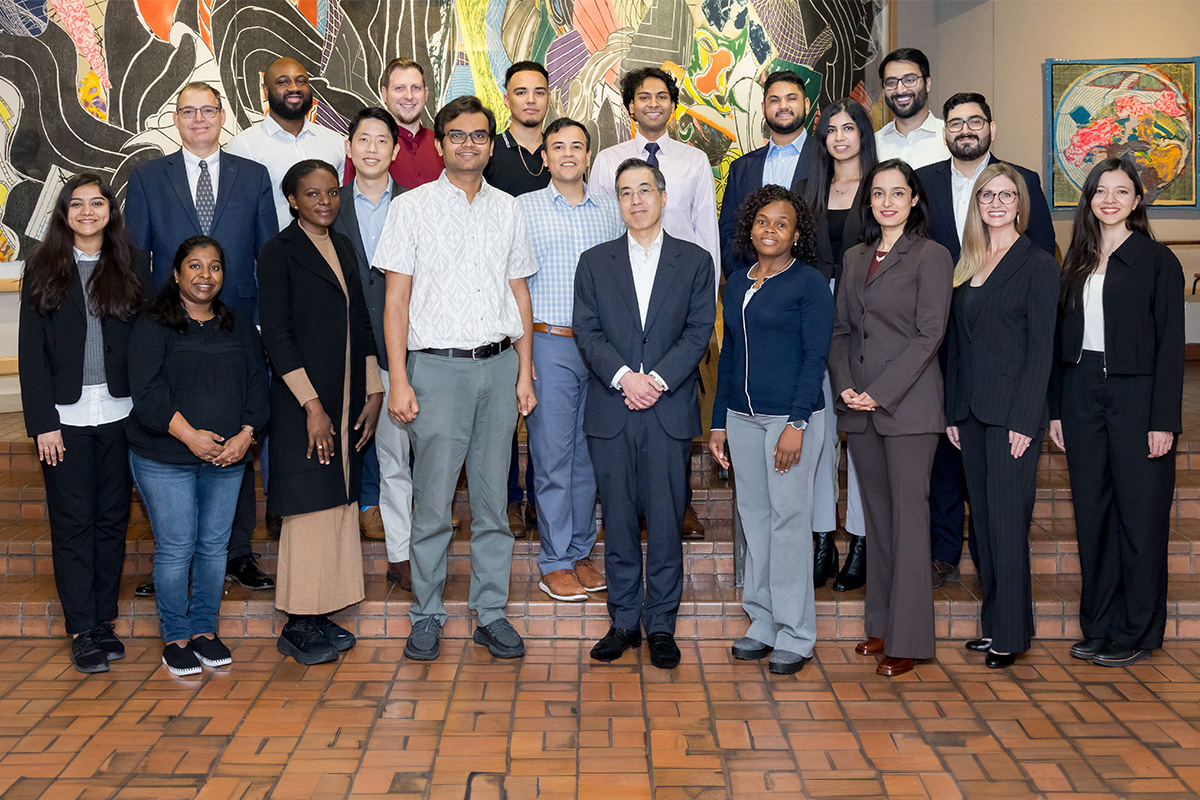 The CMRU lab members standing on steps in front of artwork