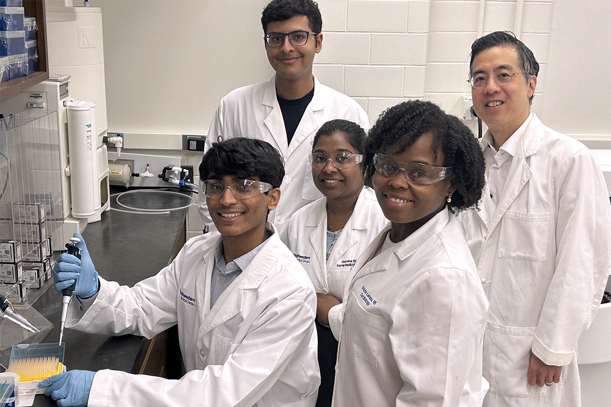 five members of the CMRU team includng Dr. Thomas Wang wearing white lab coats standing in a laboratory setting